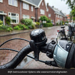 Zwarte R2B fietsbel met regendruppels op het fietsstuur, betrouwbaar te gebruiken tijdens verschillende weersomstandigheden.
