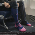 Reiziger draagt R2B compressiekousen  blauw tijdens een vlucht voor meer comfort.