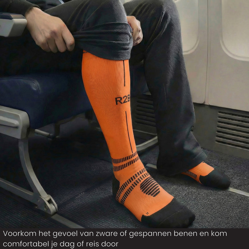 Reiziger draagt R2B compressiekousen  oranje tijdens een vlucht voor meer comfort.
