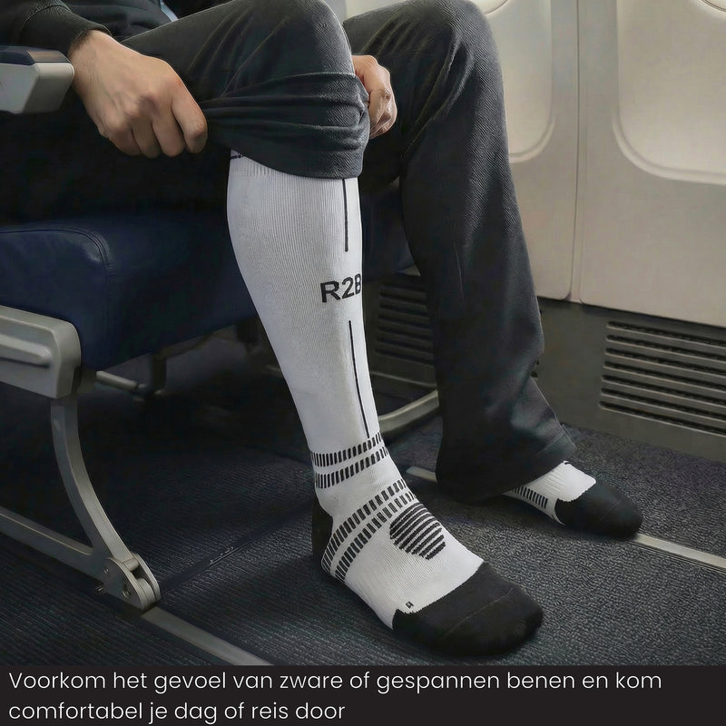 Reiziger draagt R2B compressiekousen  wit tijdens een vlucht voor meer comfort.