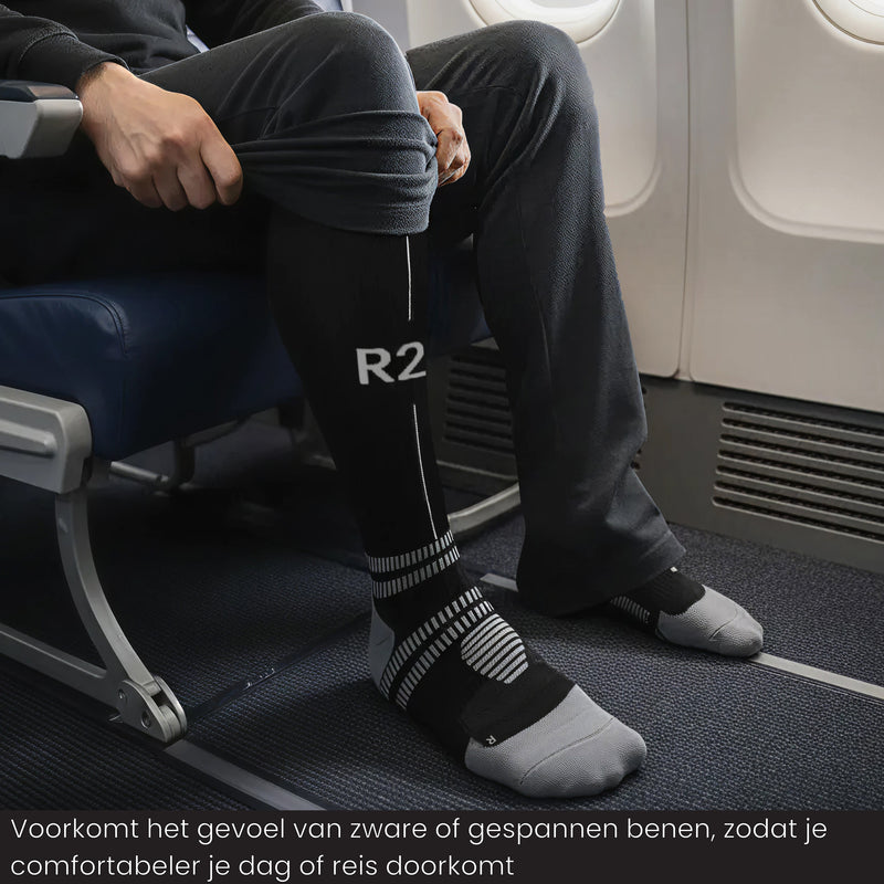 Reiziger draagt R2B compressiekousen  tijdens een vlucht voor meer comfort.