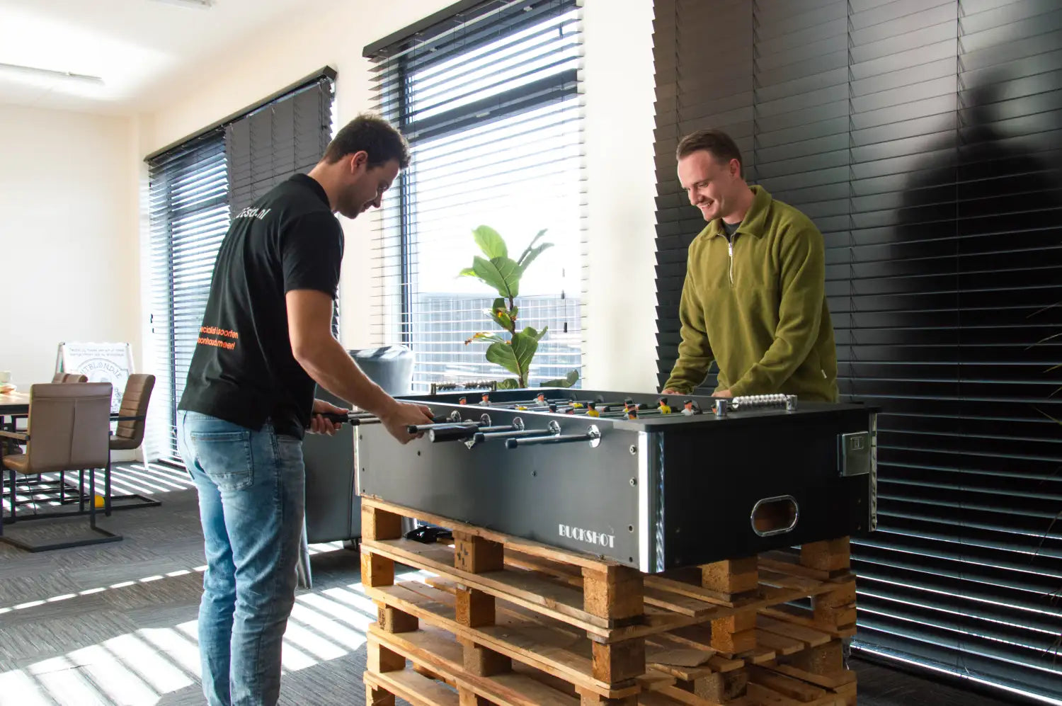 Zwarte foosballtafel met zilveren accenten en een strak, modern ontwerp.