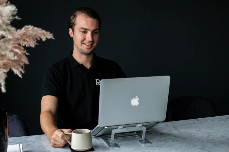 Zilveren Apple MacBook-laptop op een standaard