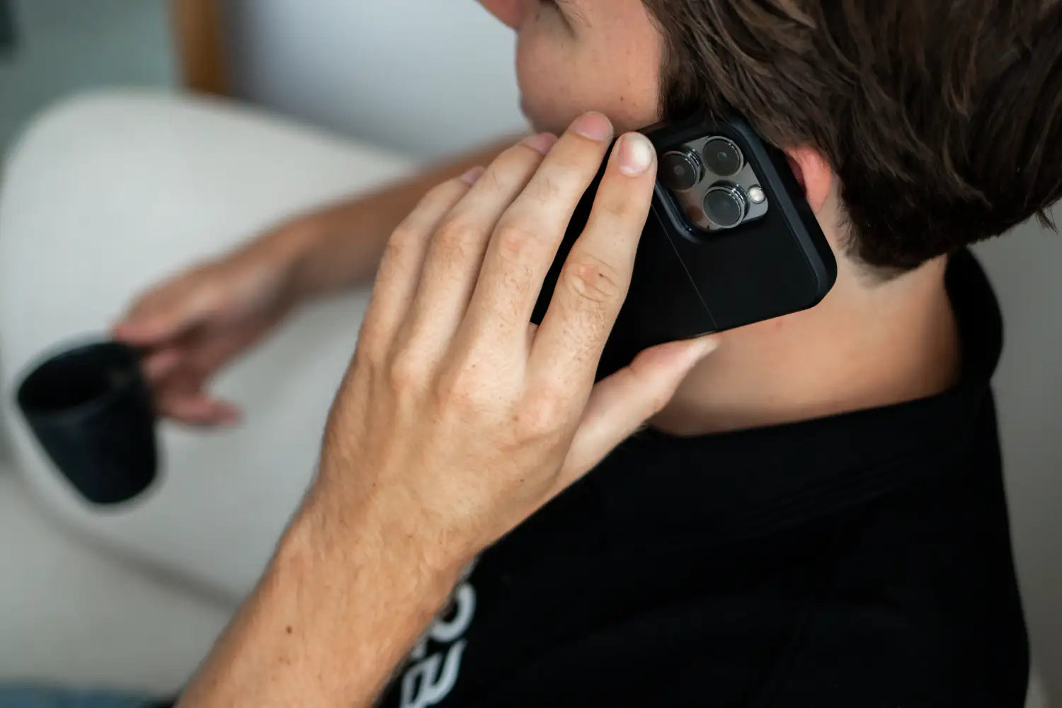 Zwarte telefoon met drievoudige cameralens-module in een beschermende case