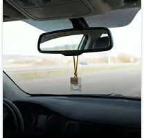 Een duidelijke, rechthoekige geurhanger voor in de auto die aan een binnenspiegel hangt met een ketting in goudkleur.
