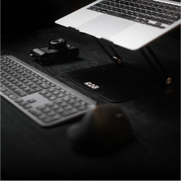 Zilveren laptop op een zwarte verstelbare standaard
