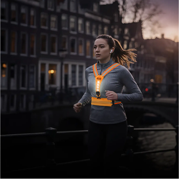 Helderoranje r2b reflecterend hardloopvest met een centrale led-verlichting.