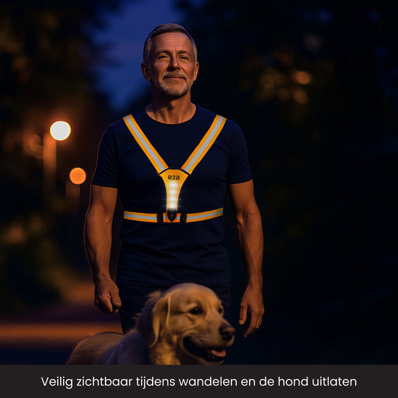 Man is een hond aan het uitlaten in het donker met een verlicht hardloopvest aan